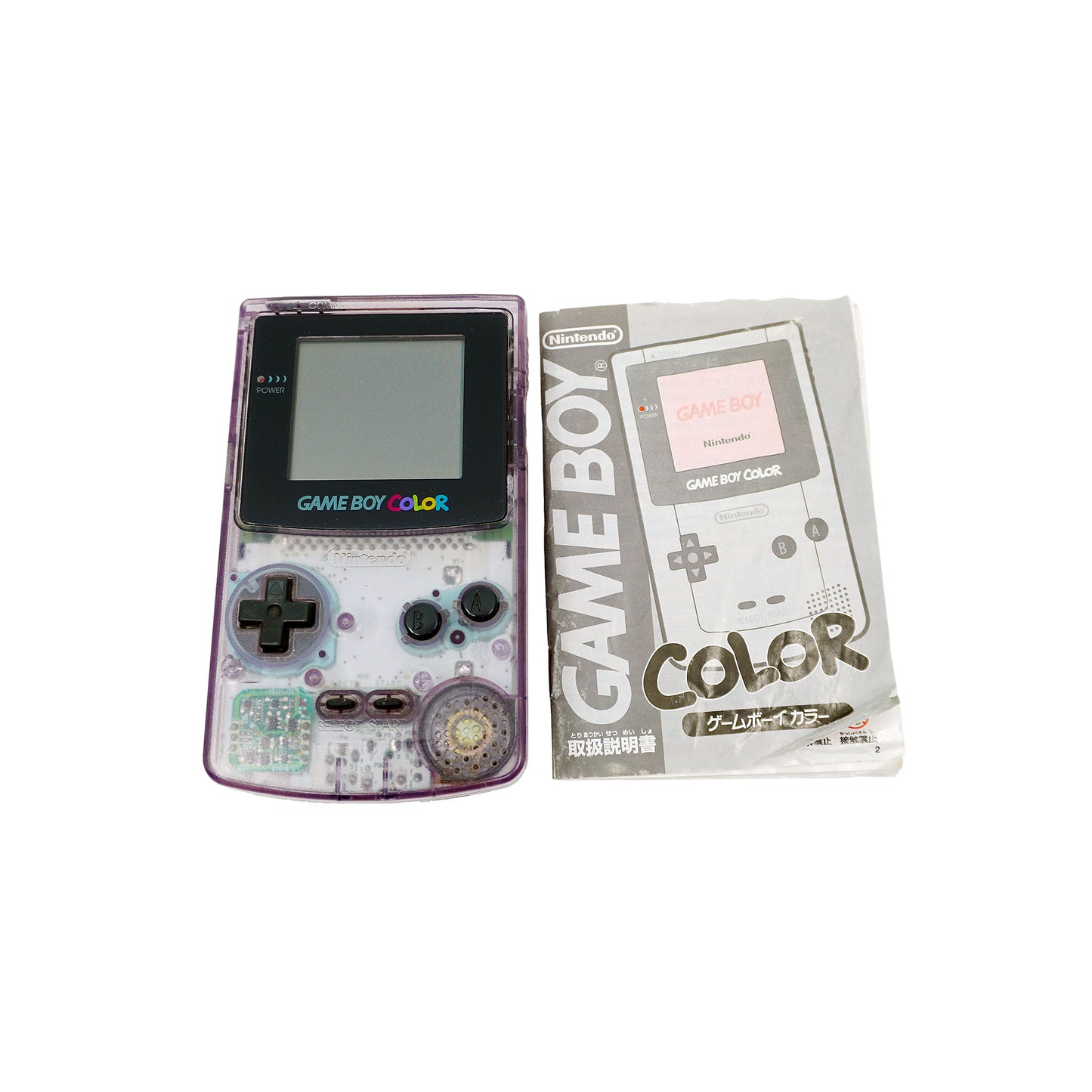 Ein Game Boy Color in Atomic Purple liegt neben der originalen, japanischen Bedienungsanleitung
